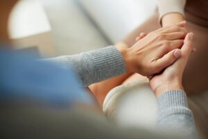 Supportive hand-holding gesture representing care and emotional support in trauma recovery